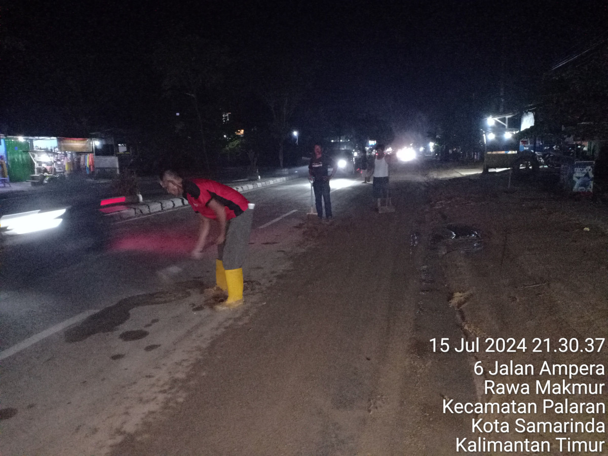 Membersihkan lumpur di jalanan