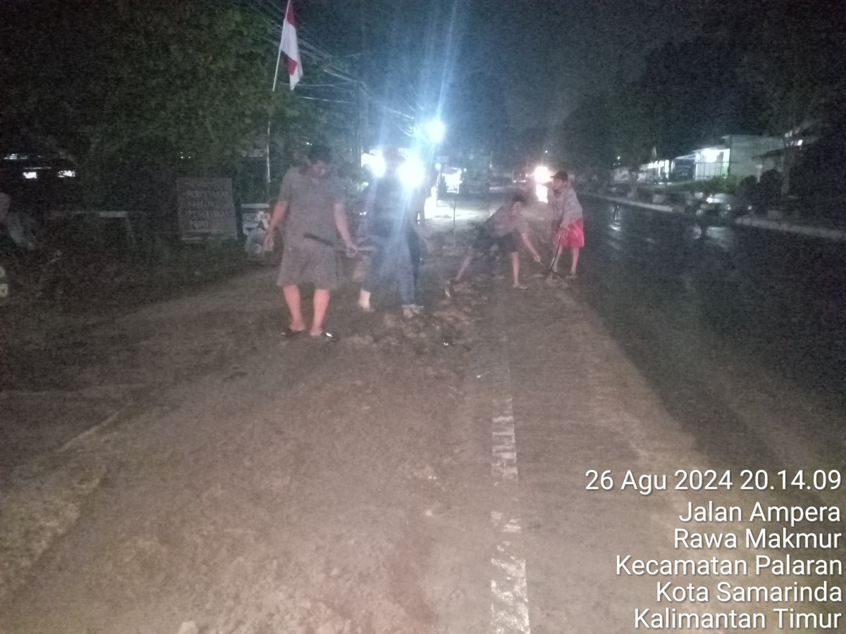 Membersihkan Lumpur di jalan Raya