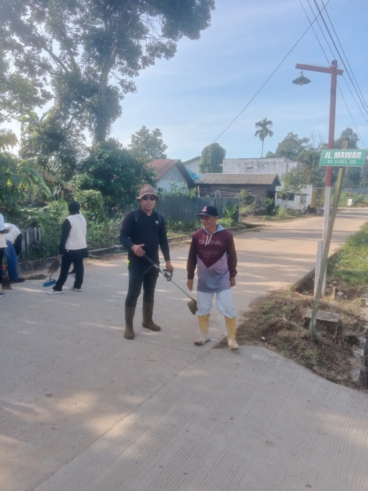 Kerja bakti membersihkan Rumput dan parit dikirikanan jalan