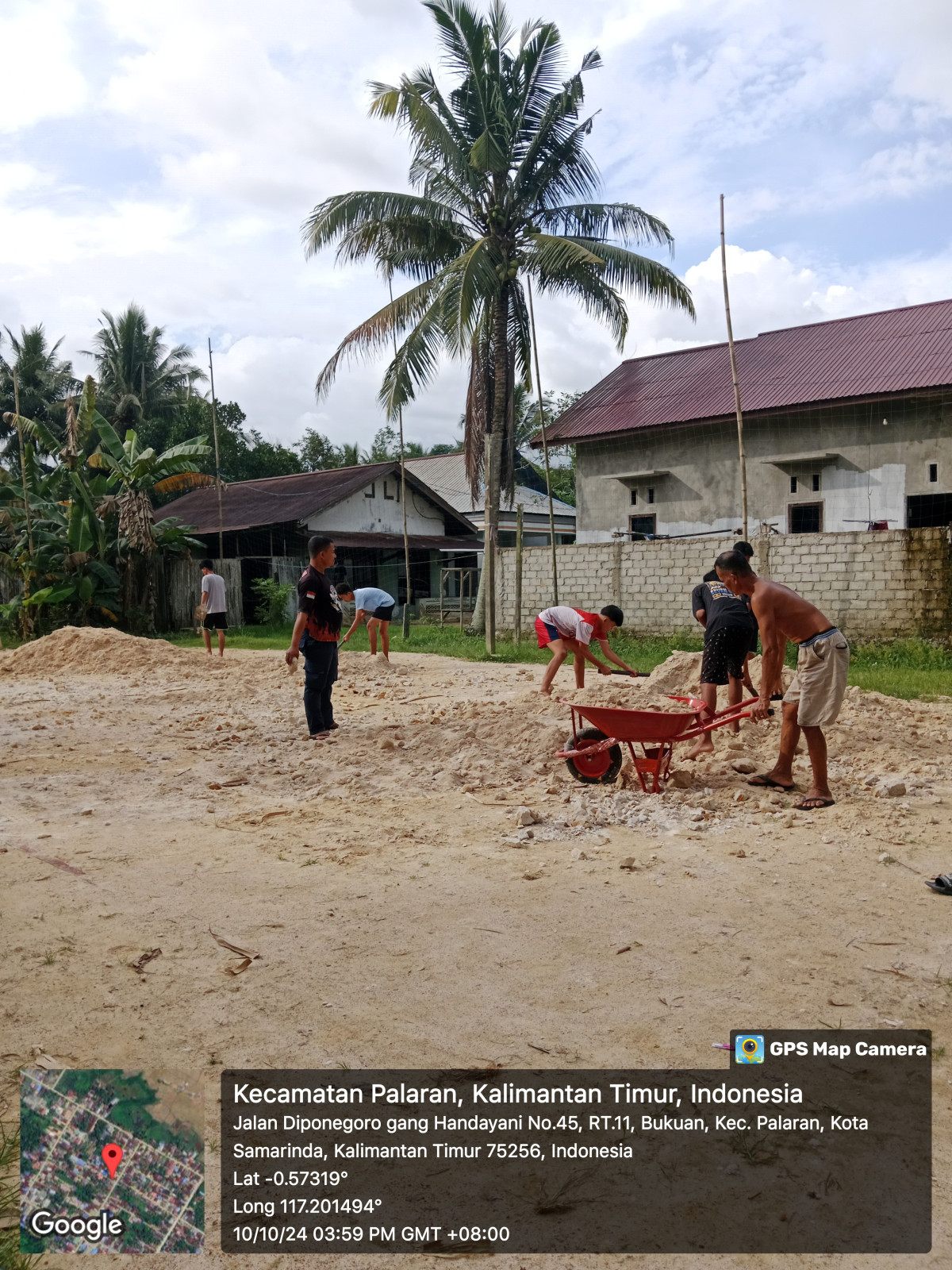 Meratakan tanah uruk di lapangan volley
