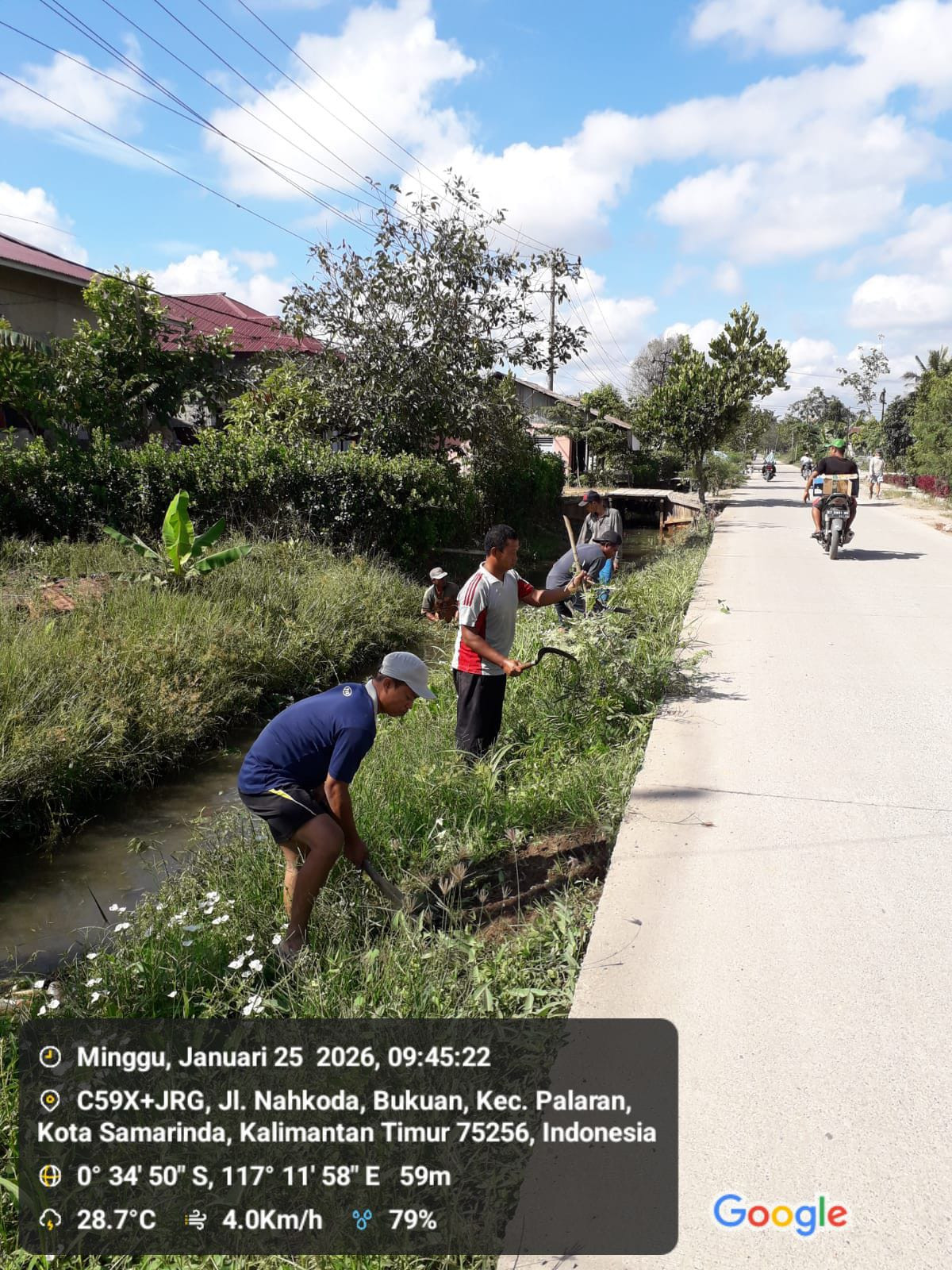Membersihkan rumput di media jalan dan parit