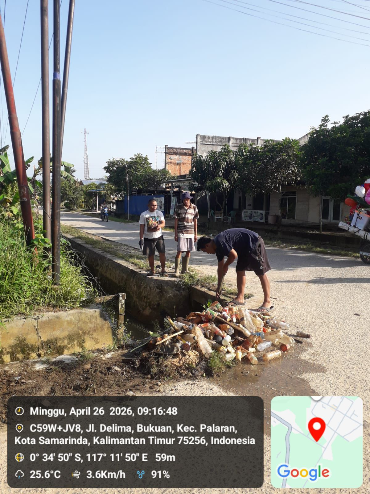 Membersihkan rumput di media jalan delima RT 15 bukuan