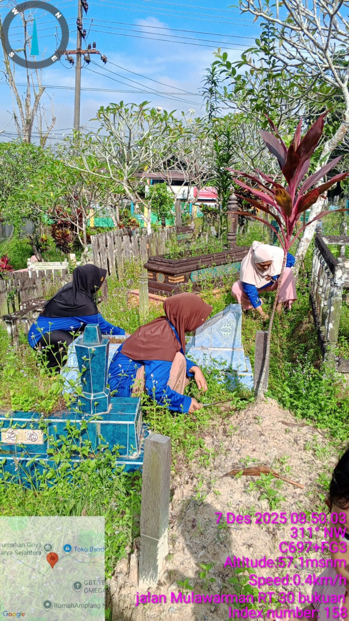 Membersihkan rumput di area Makam dan mengangkat material