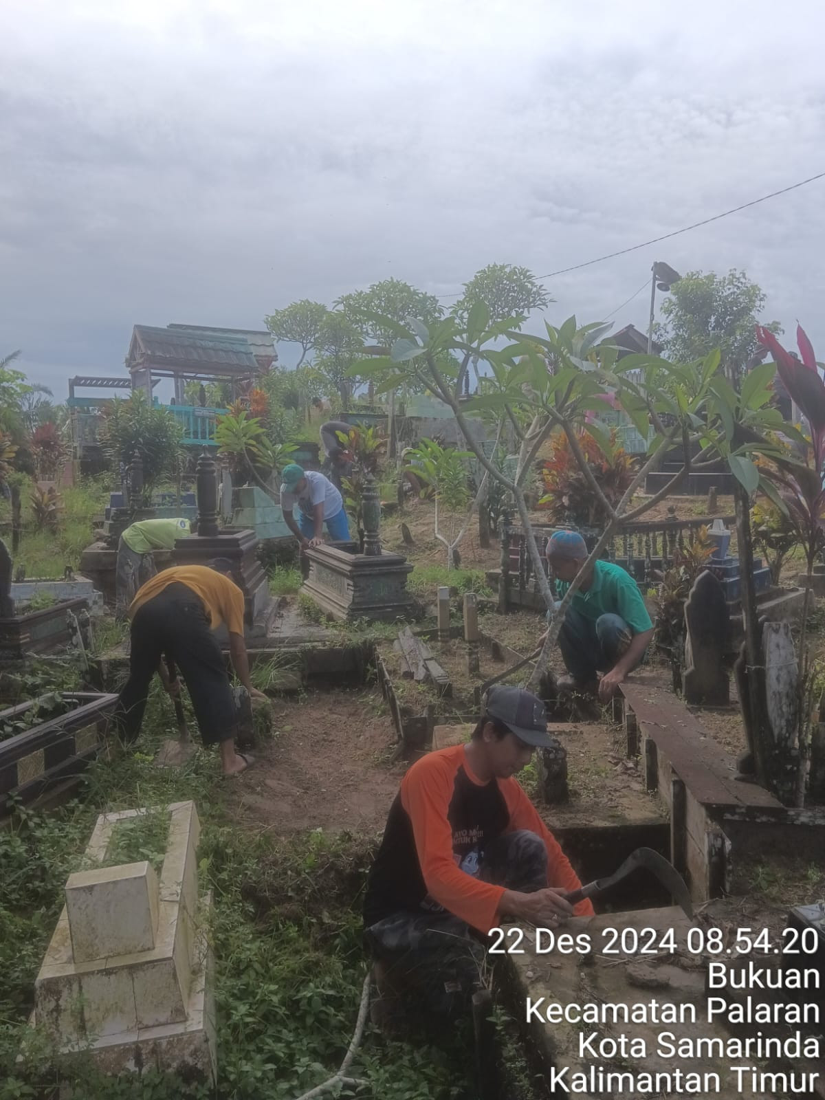 Membersihkan area makam