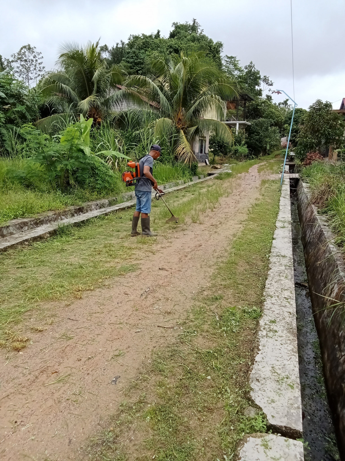 Pembersihan Parit dan rumput badan jalan poros nahkoda RT 34 BUKUAN