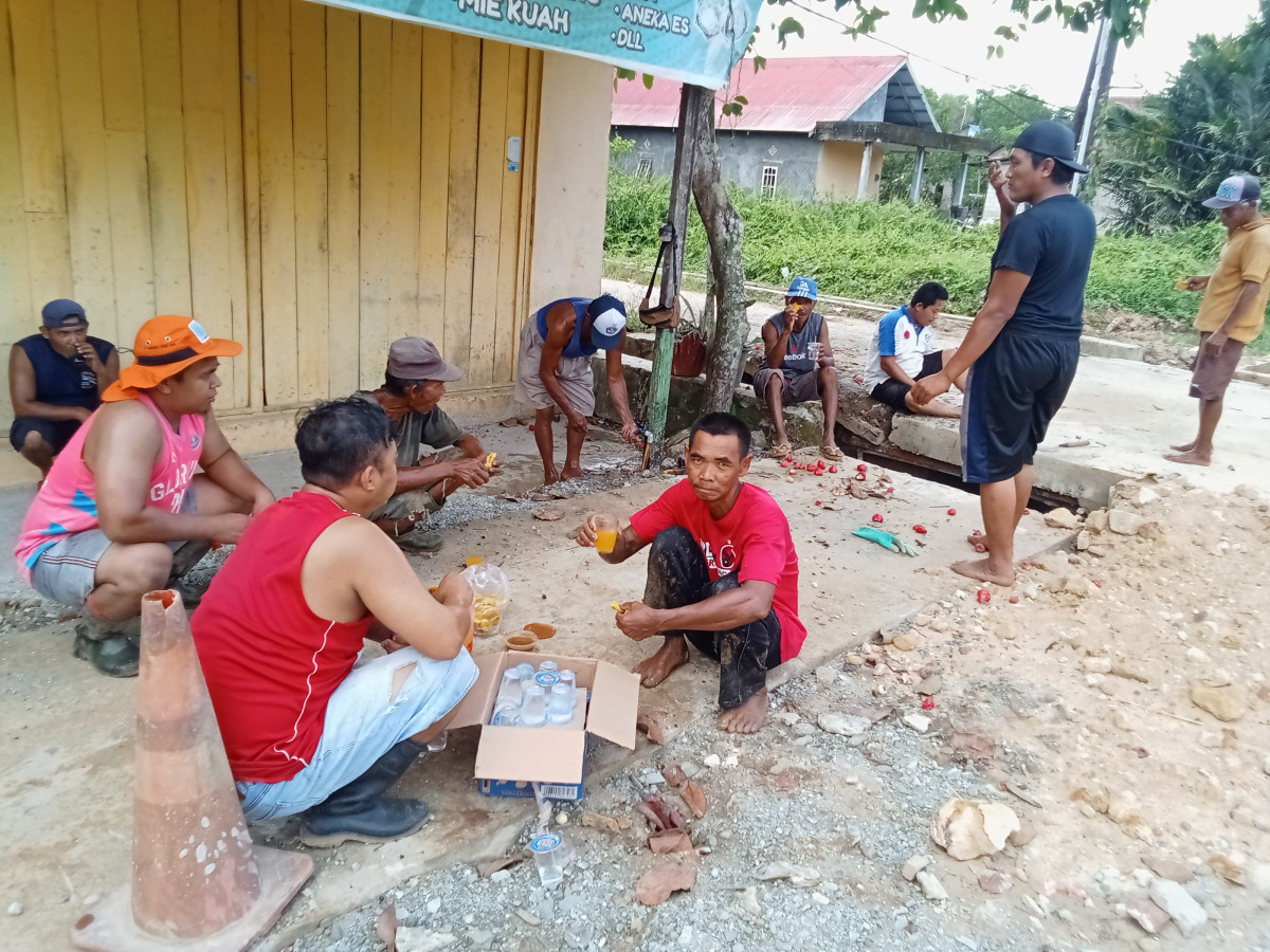 Membersihkan drainase jalan poros RT 34