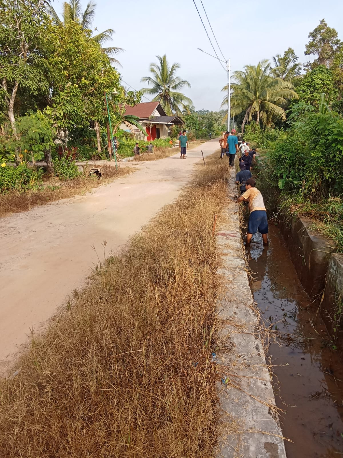 Membersihkan jalan dan saluran irigasi/parit di Jl Salak RT 44