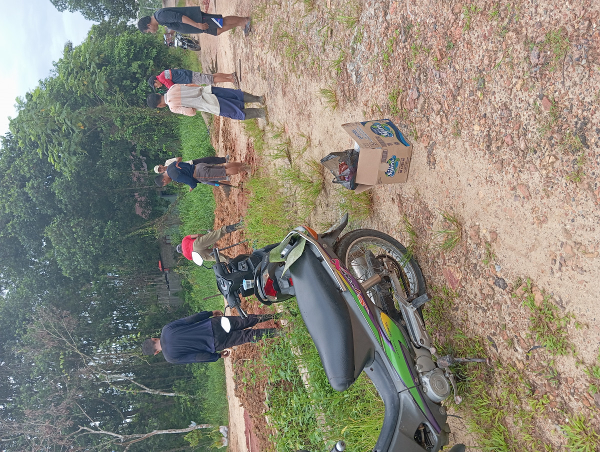 Kegiatan kerja bakti RT 44 membersihkan jalan dan drainase di jalan kuburan muslim
