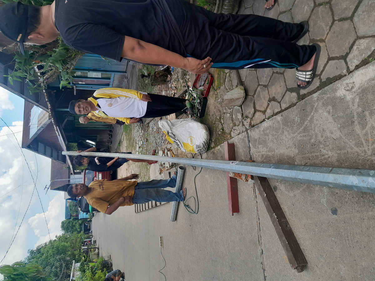 Gotong royong merobohkan gapura dan perbaikan lampu jalan