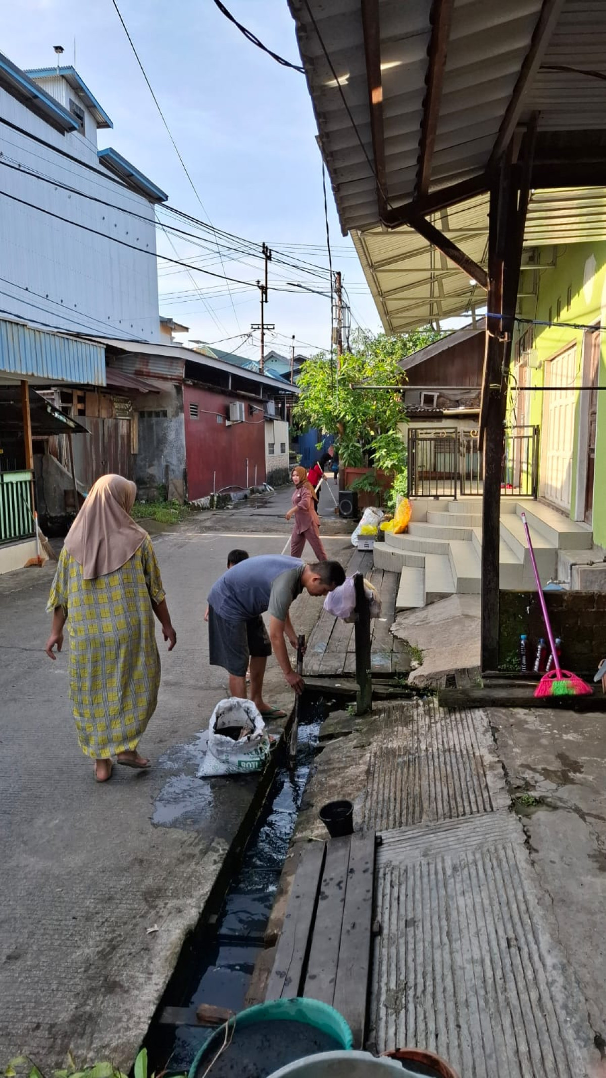 Membersihkan sampah di parit