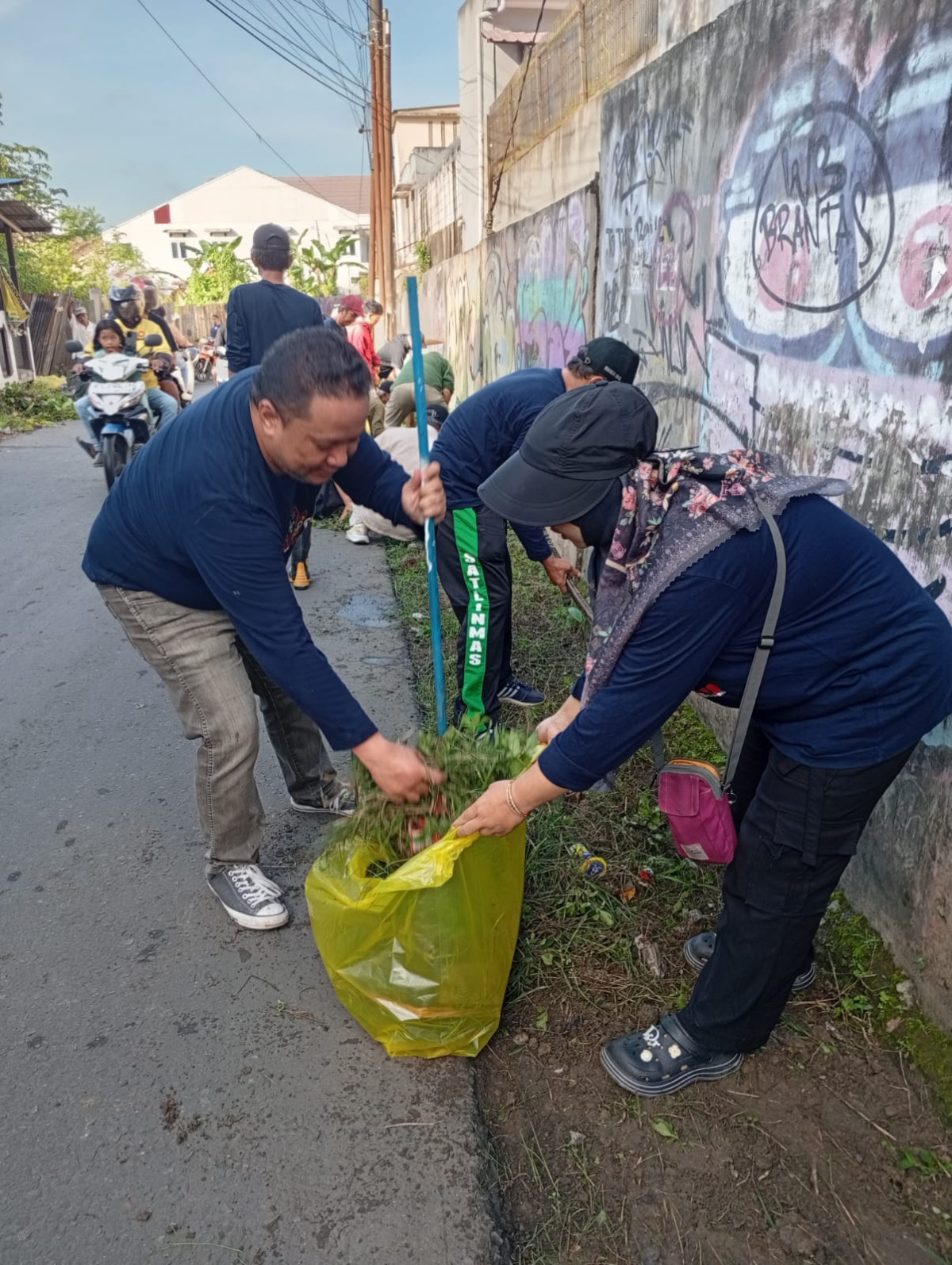 Membersihkan sampah dan rumput di eks tps jl. Siti Aisyah
