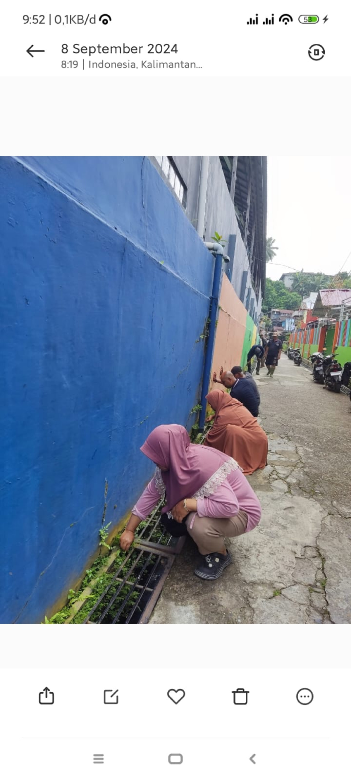 Membersihkan rumput dan sampah di wilayah rt.06