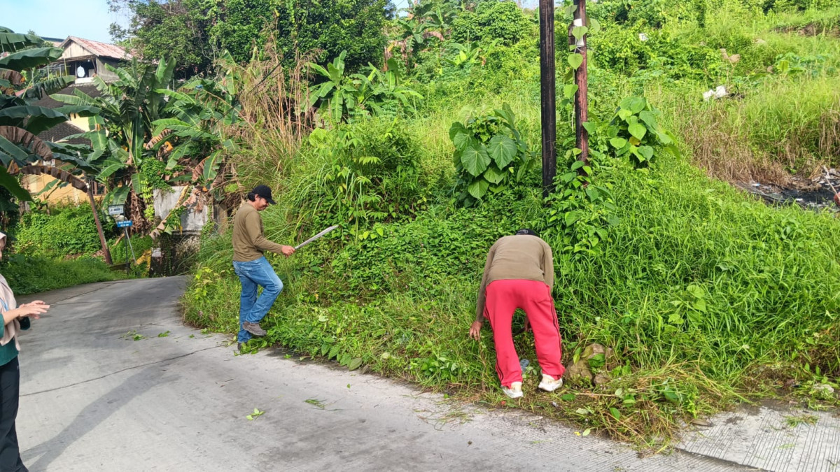 Membersihkan rumput di jl. H. Basao rt. 29