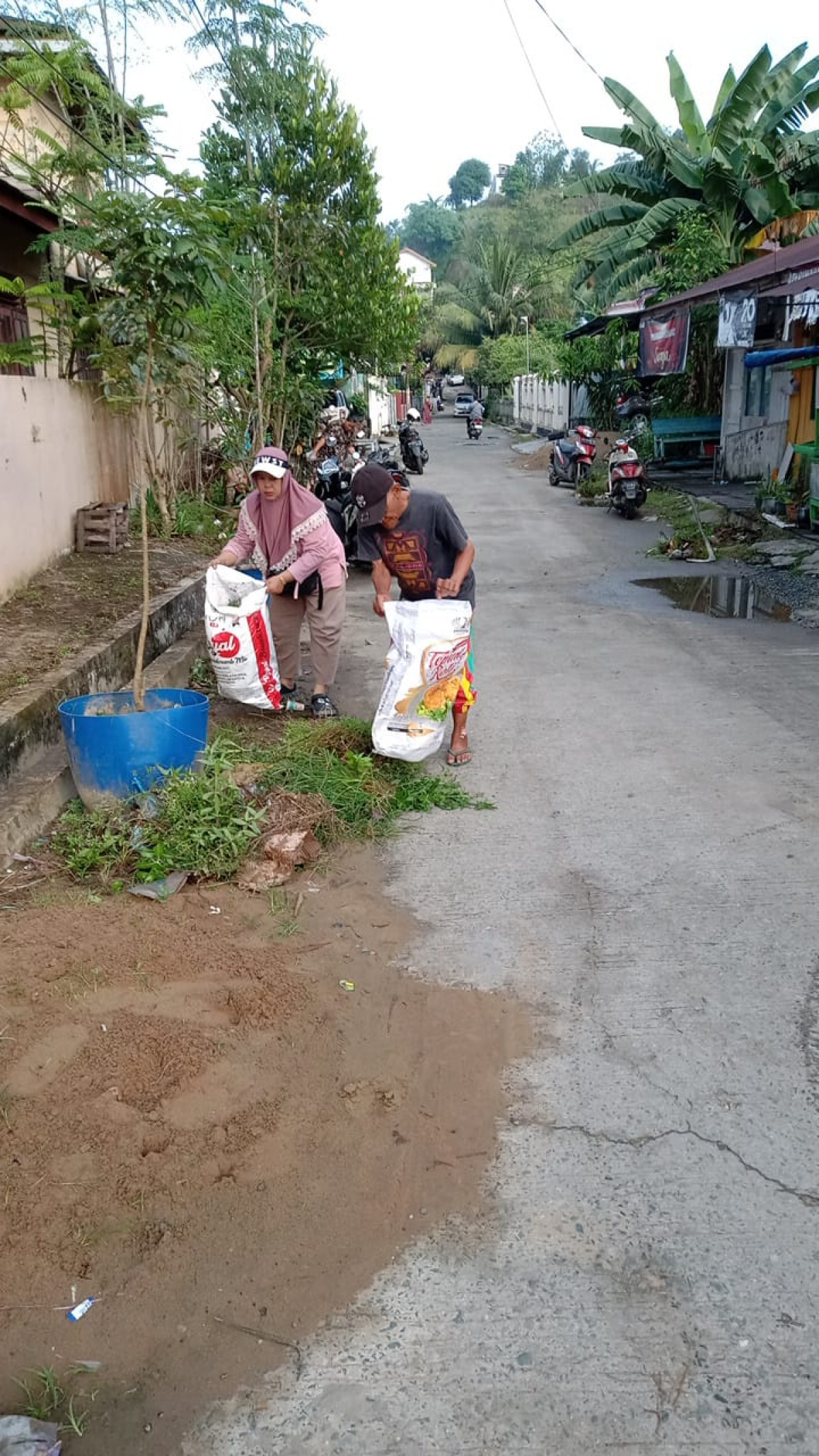 Gotong royong membersihkan rumput dijalan, dan pinggir drainase