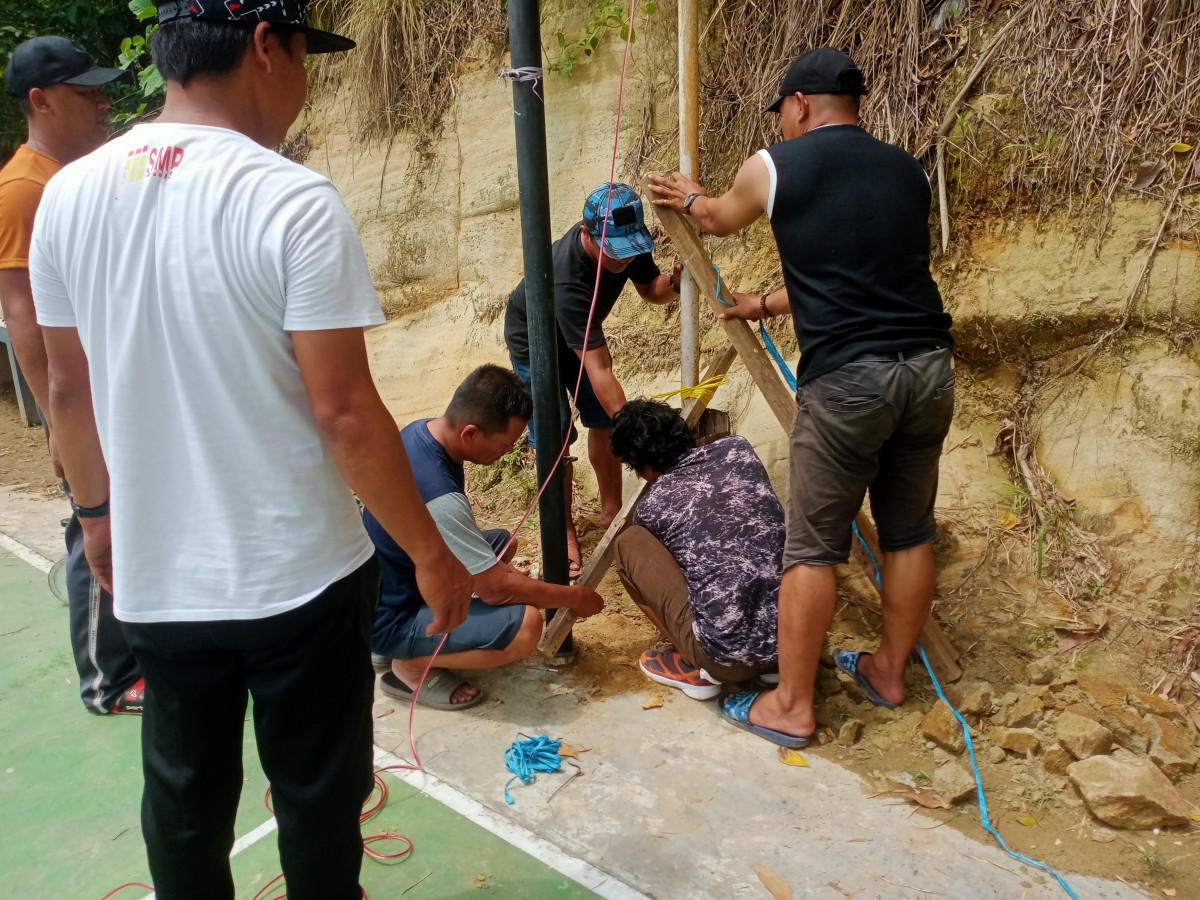 Gotong royong pindahkan tiang lampu penerangan