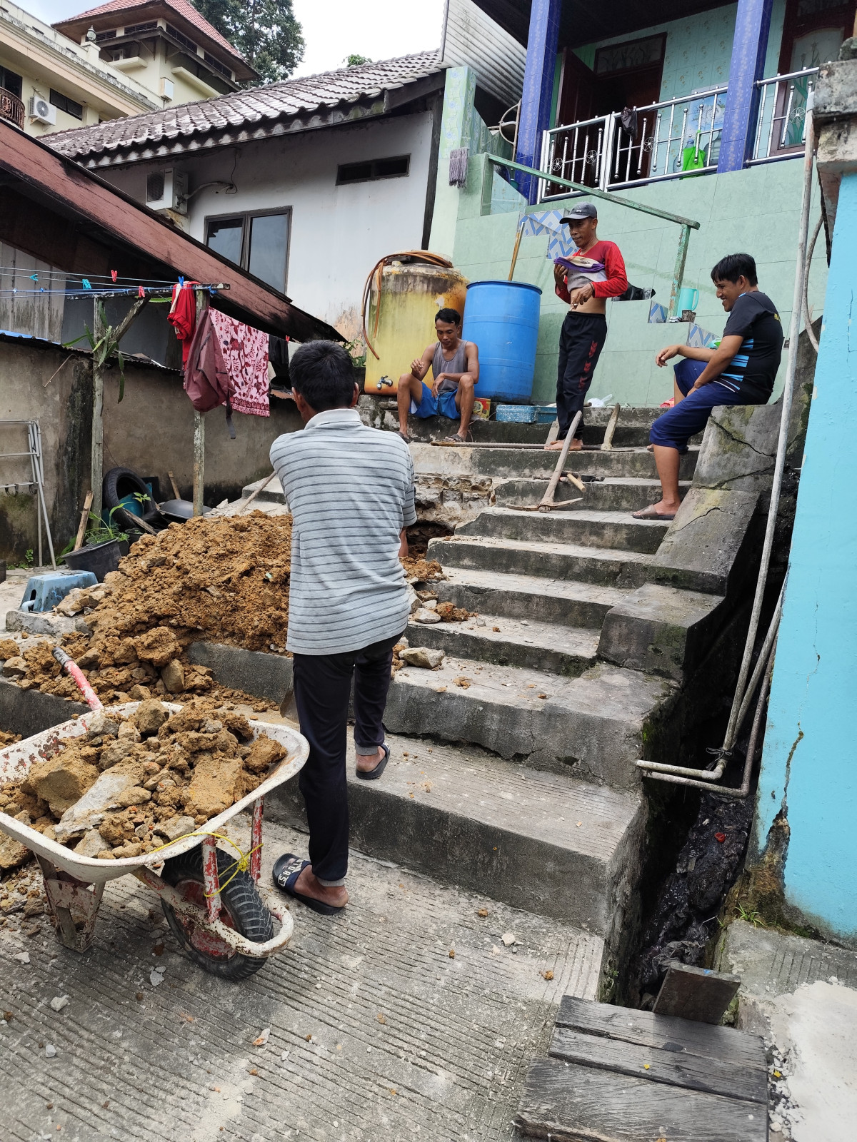 Melanjutkan perbaikan tangga rumah warga