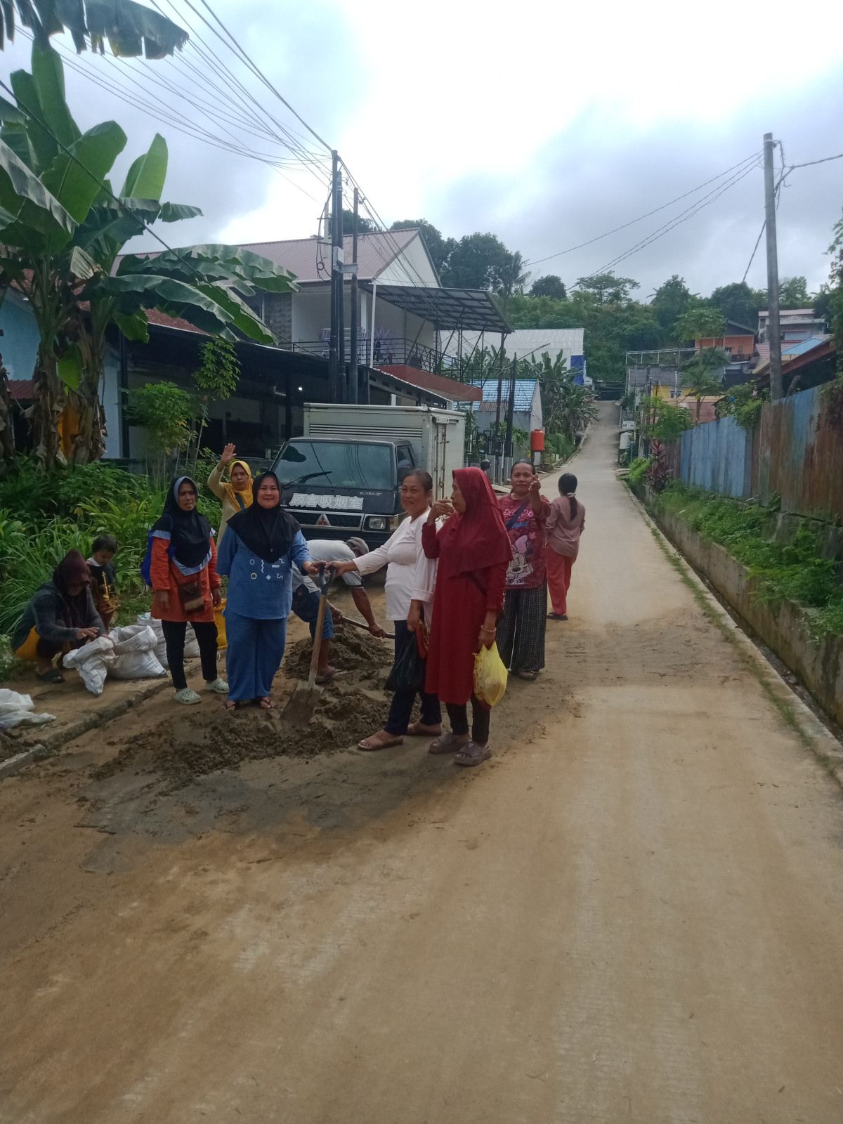 Membersihkan pasir dan sampah yang ada di jalan