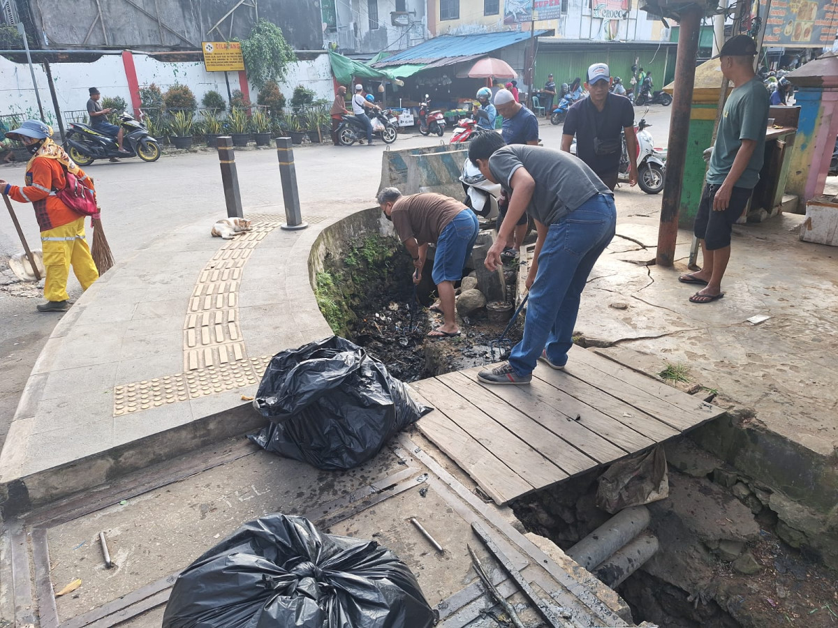 Membersihkan drenase simpang 3 Jln Perniagaan dri arah Jl. Pahlawan