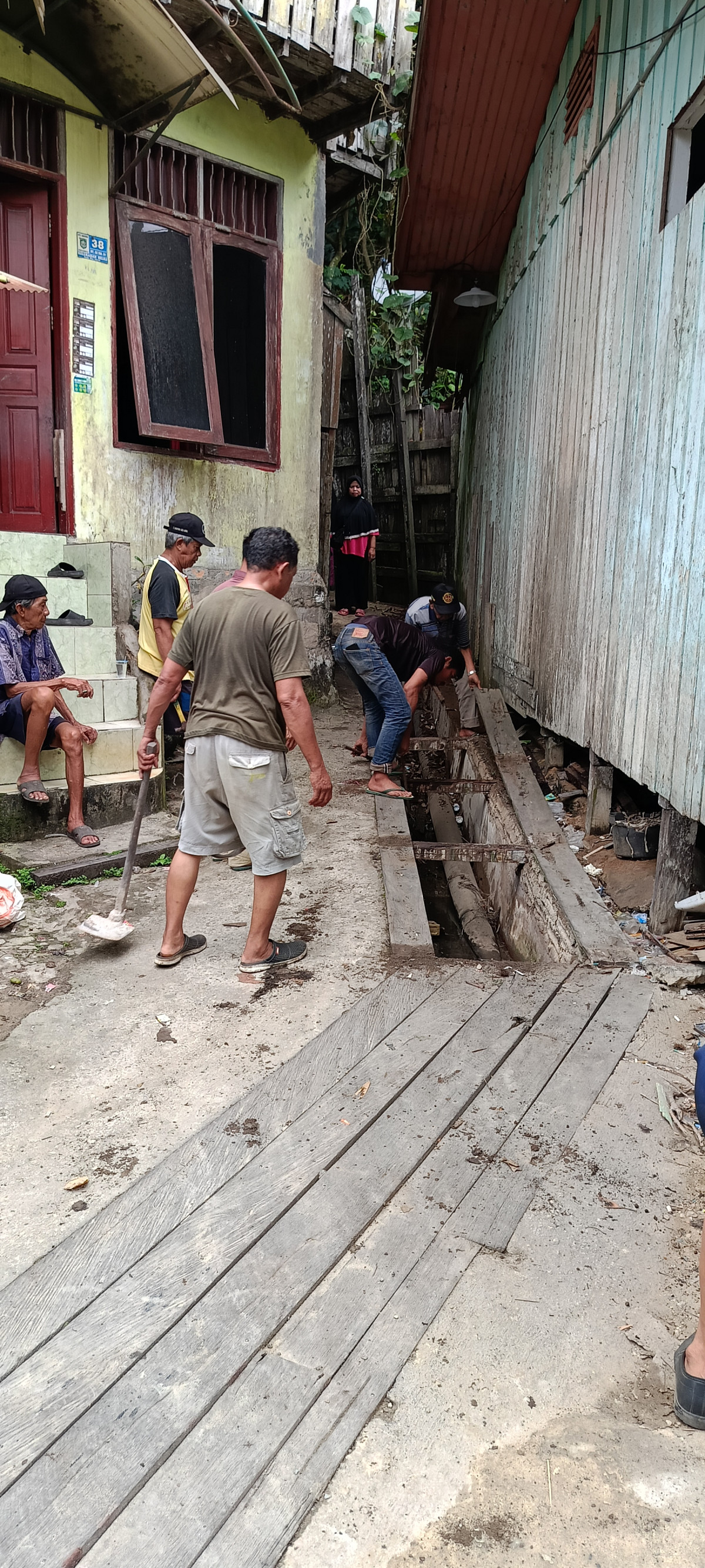 Membersihkan sampah di parit