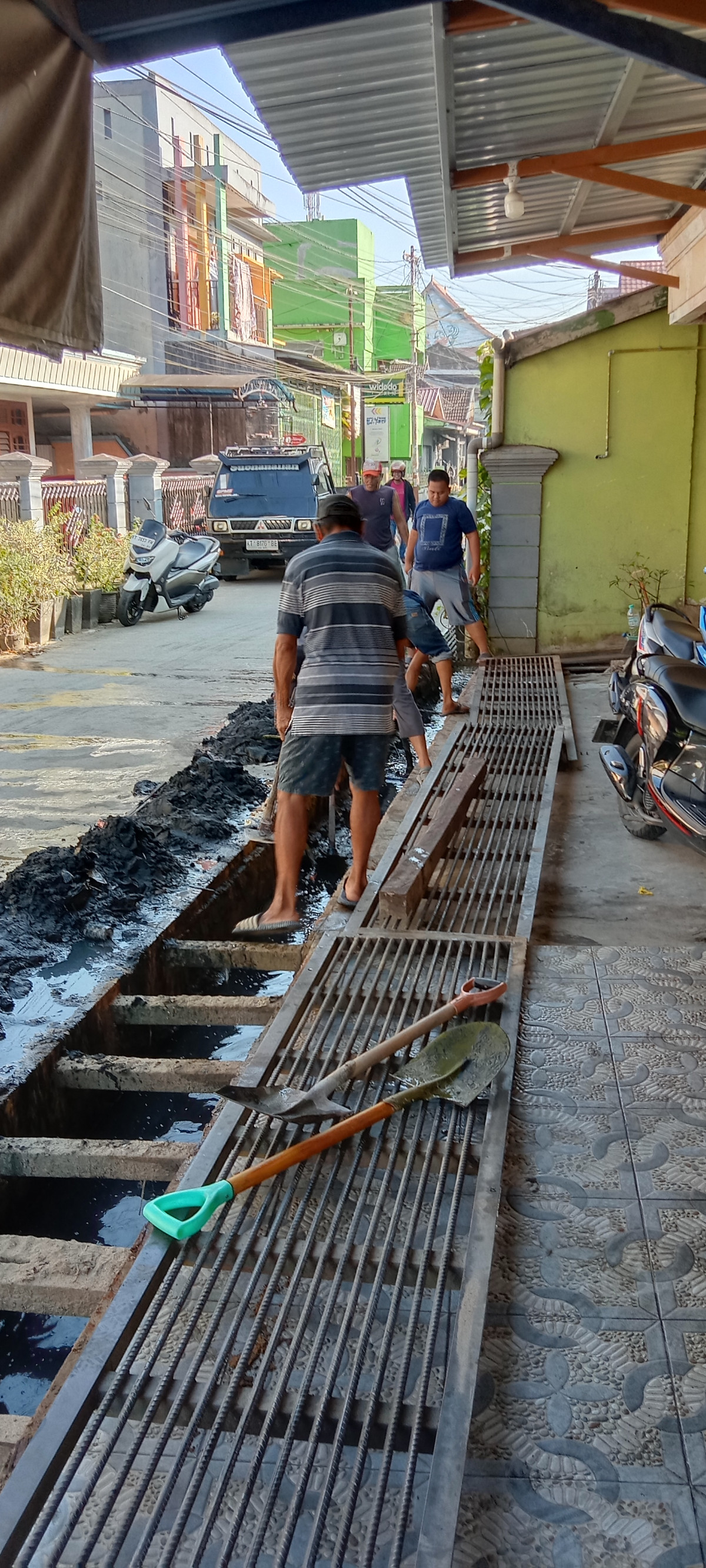 Kerja bakti / gotong royong membersihkan parit / drainase.