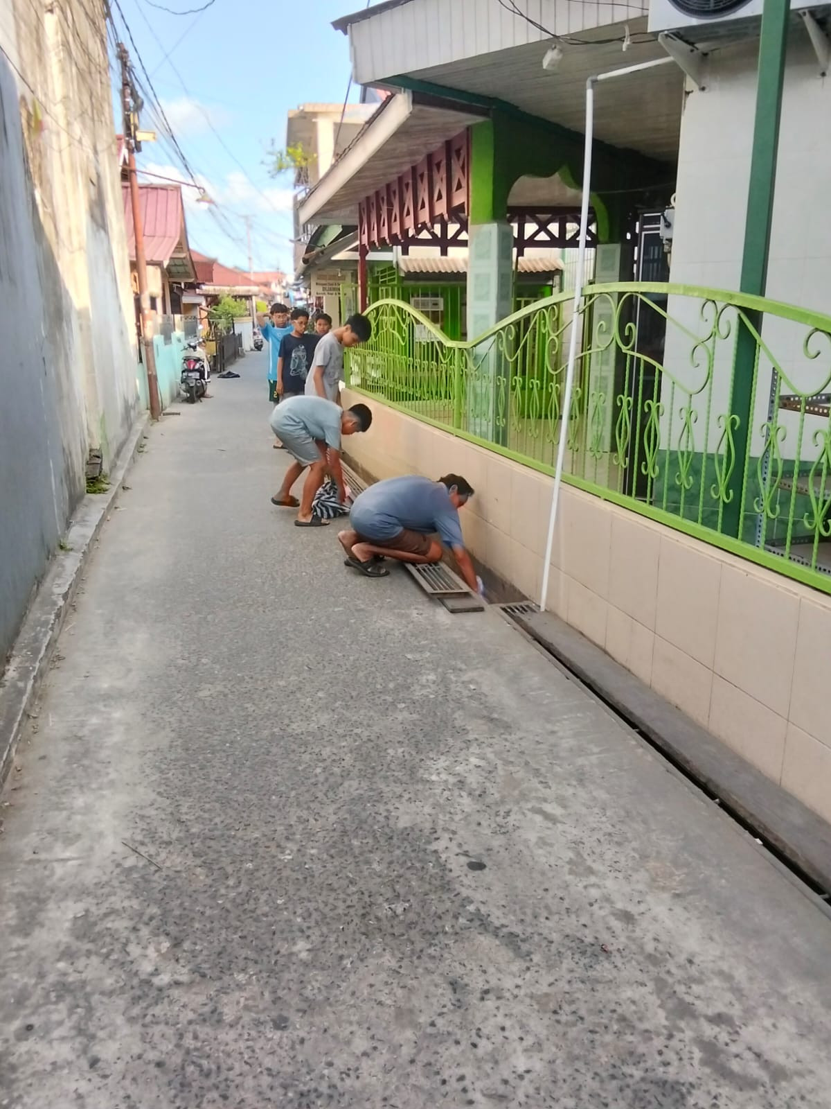 Membersihkan sampah di saluran parit langgar Al mujahidin