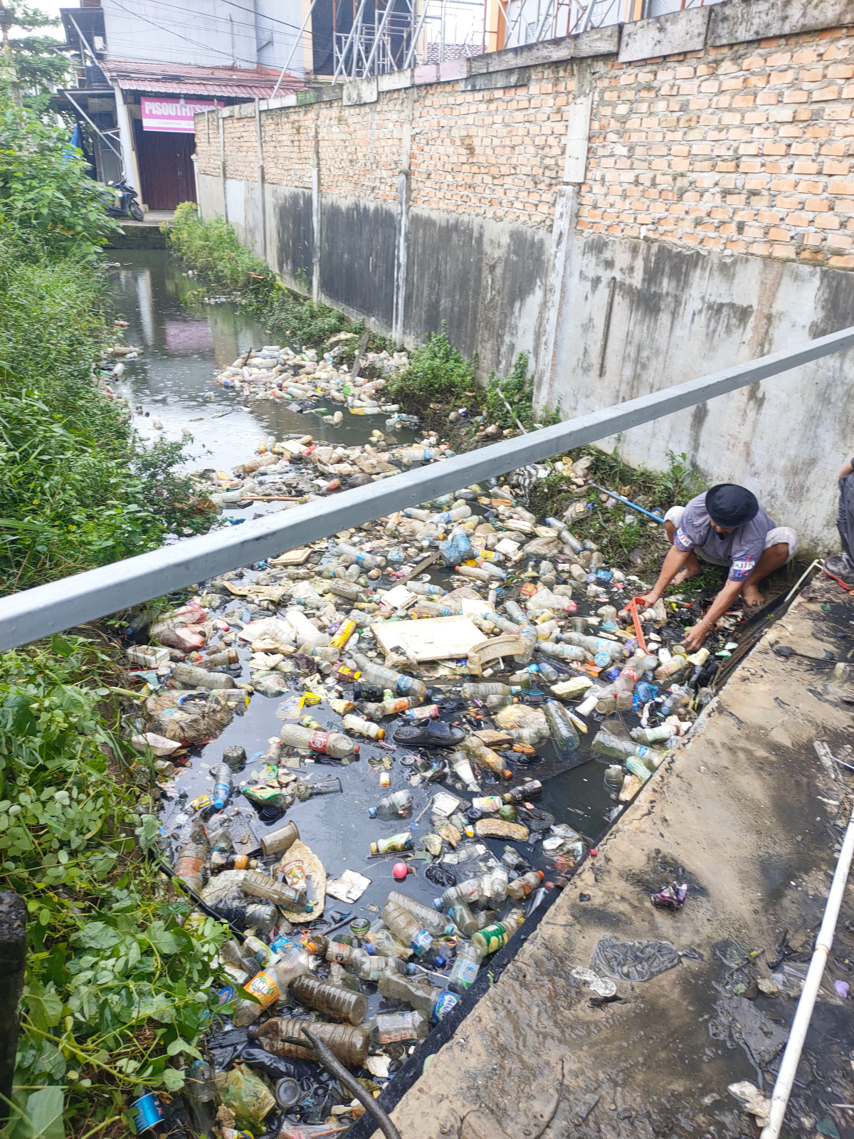 membersihkan anak sungai yang ada di samping gedung eramart fresh