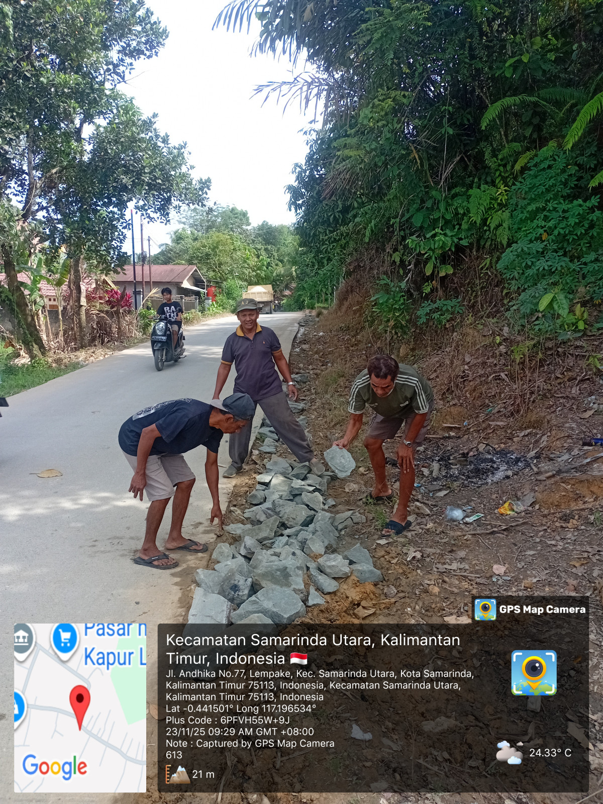 Menyemprot rumput dan menata batu di jalan yg becek