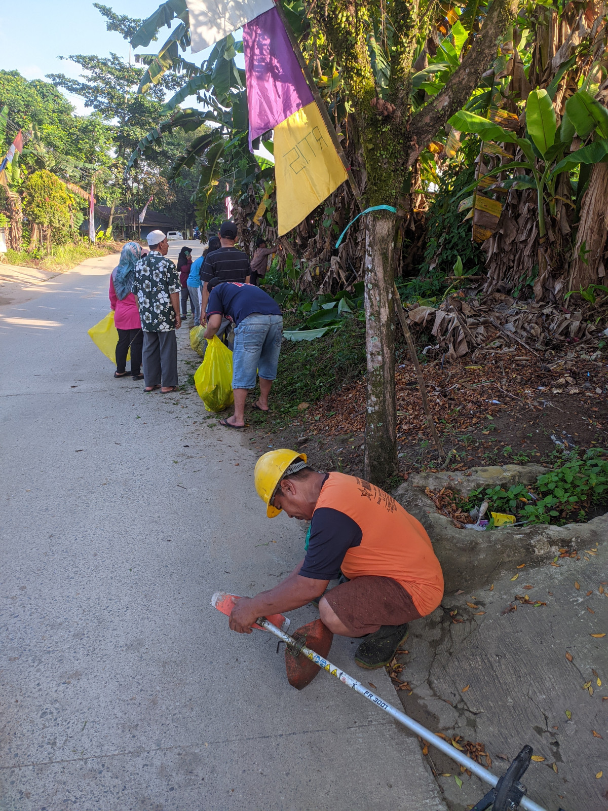 Membersihkan jalan dan lingkungan RT 15
