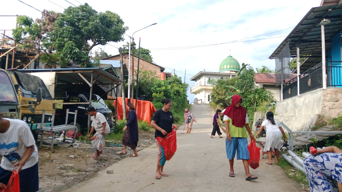 Membersihkan sampah plastik di pinggir jln