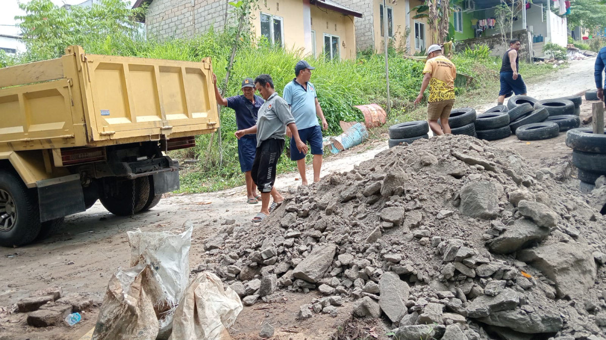 Merapikan tanah sisa longsoran