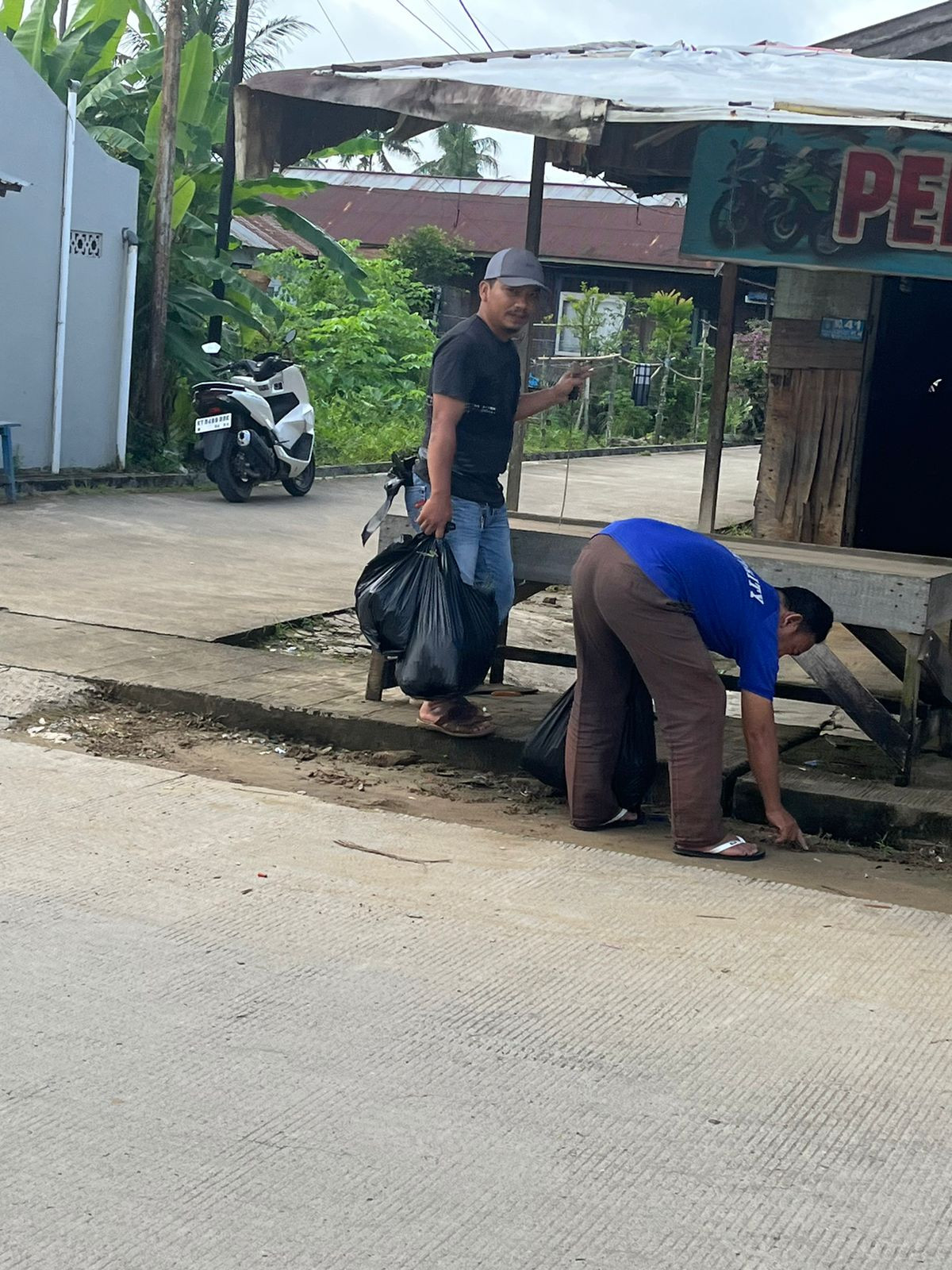 Gotong royong membersihkan drainase dan jalan dari sampah plastik