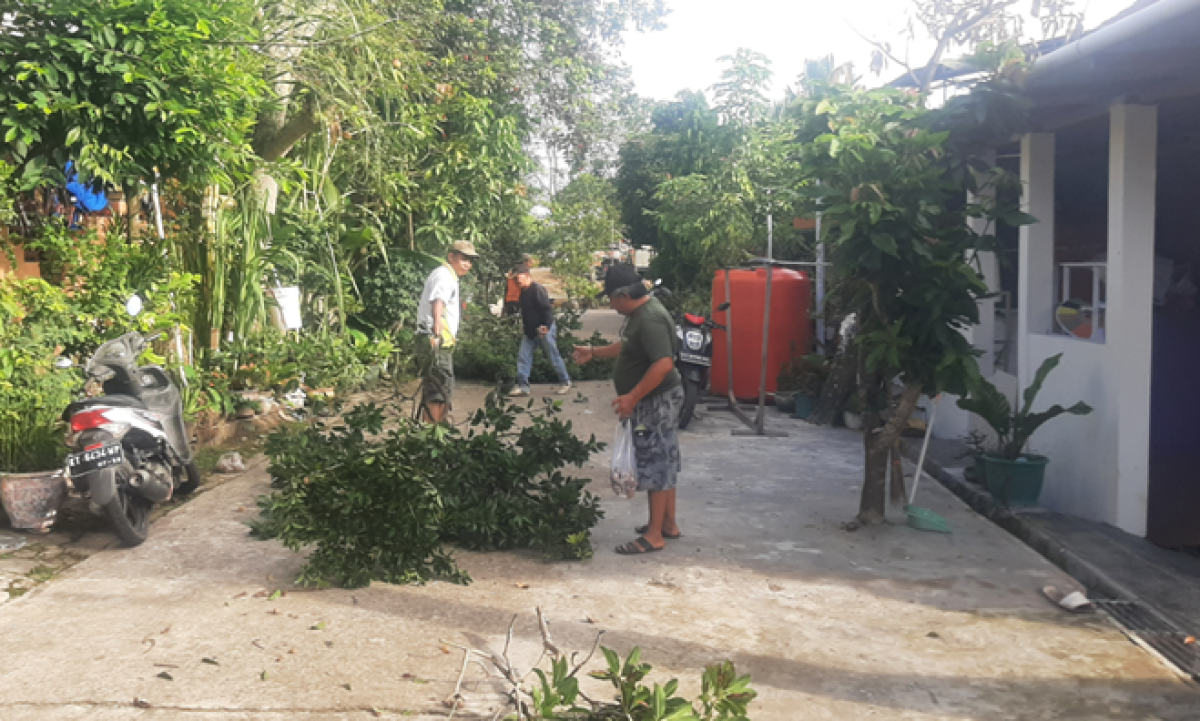 Membersihkan lingkungan sekitar simpang blok D5-D1