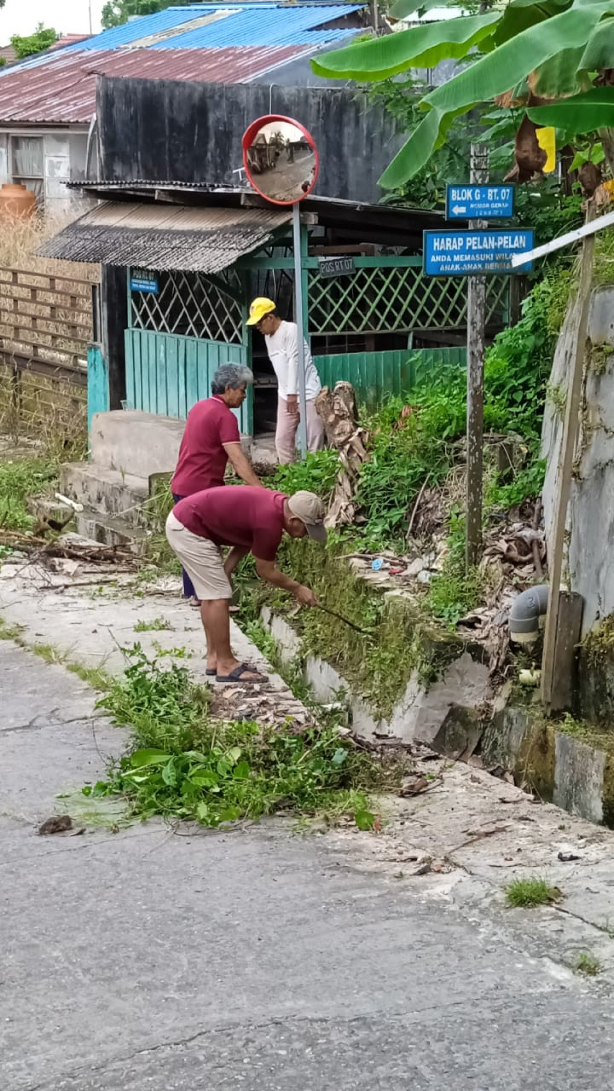 Membersihkan sekitar pos kamling