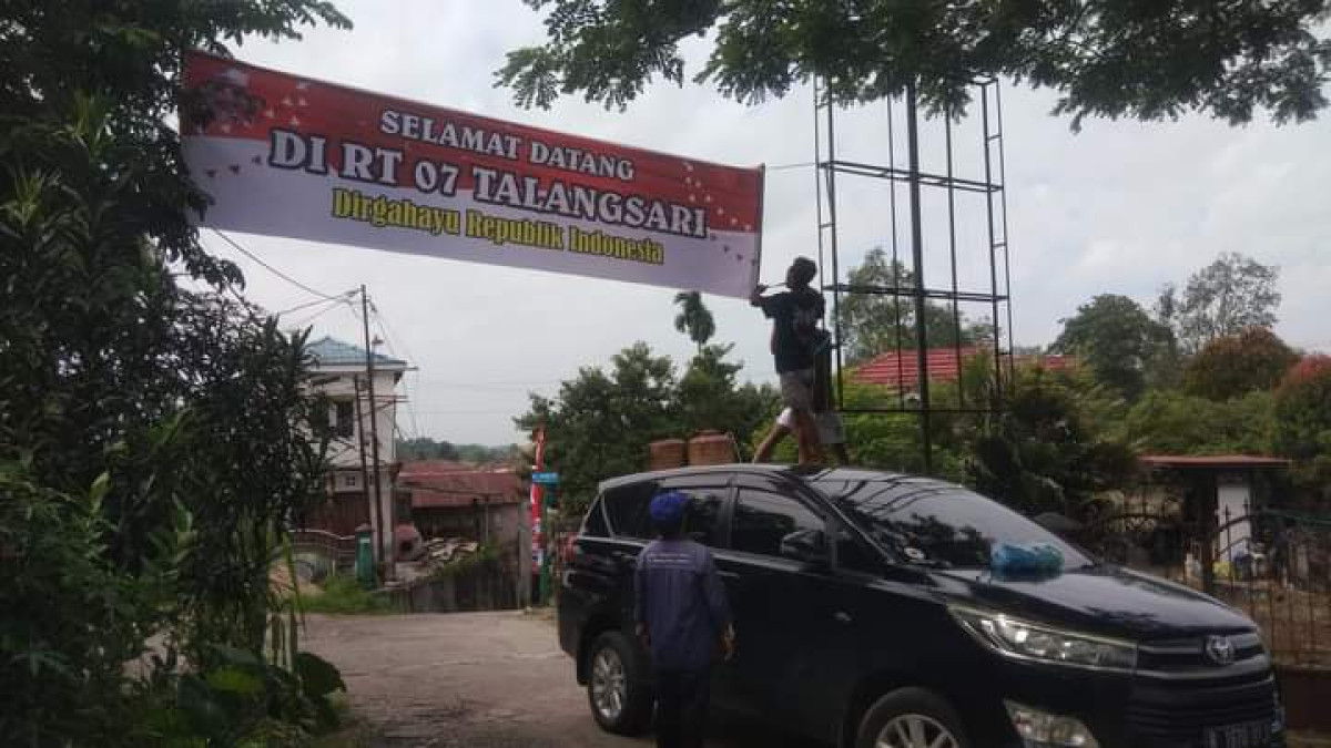 Gotong royong memasang spanduk