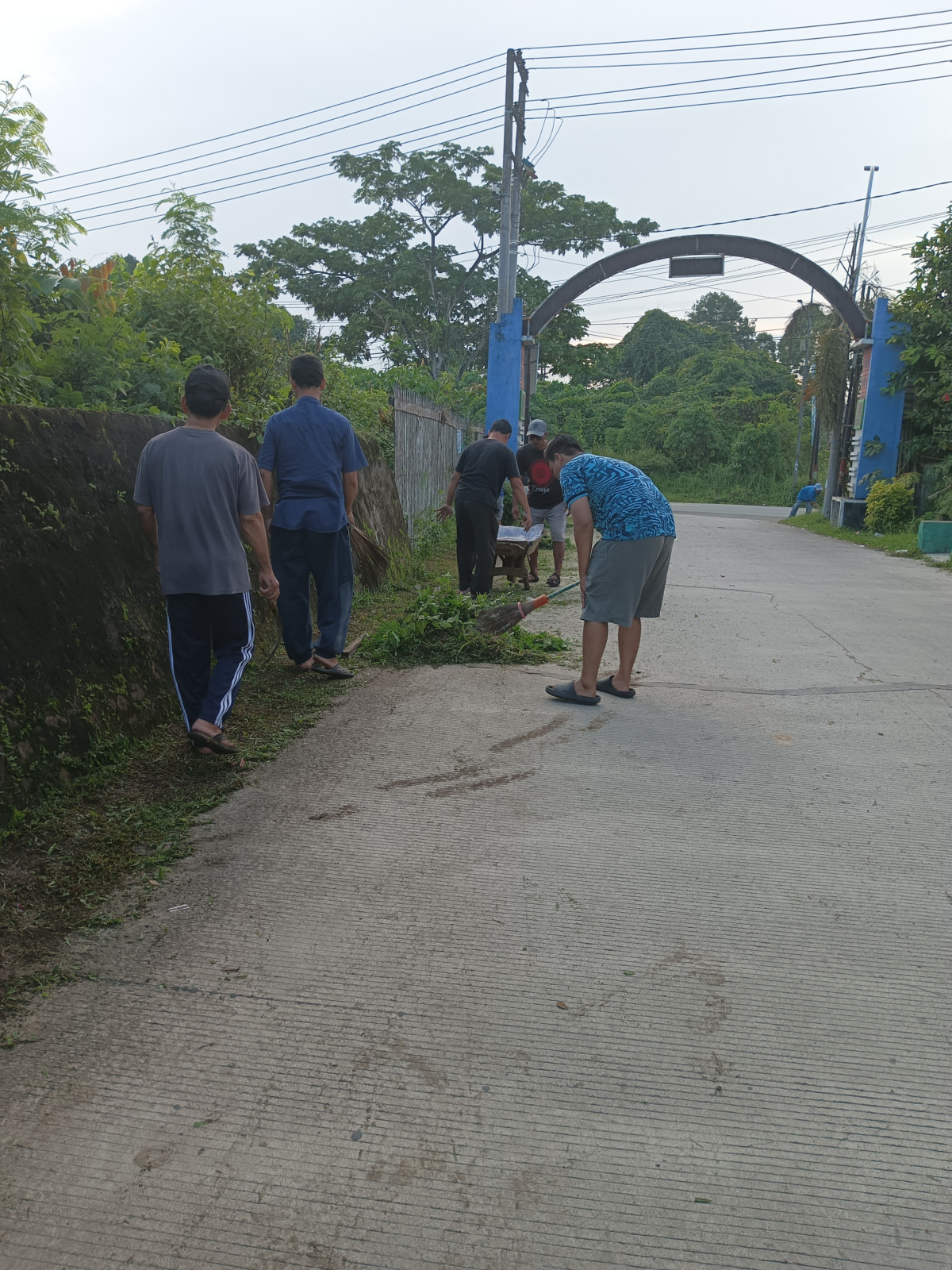 Membersihkan rumput jalan