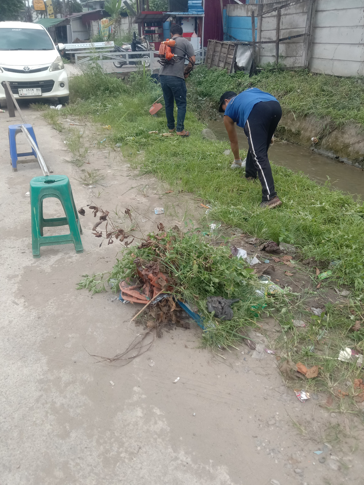 Membersihkan rumput di pinggir paret dari Asrama Ayu Sampai Samping Rutan