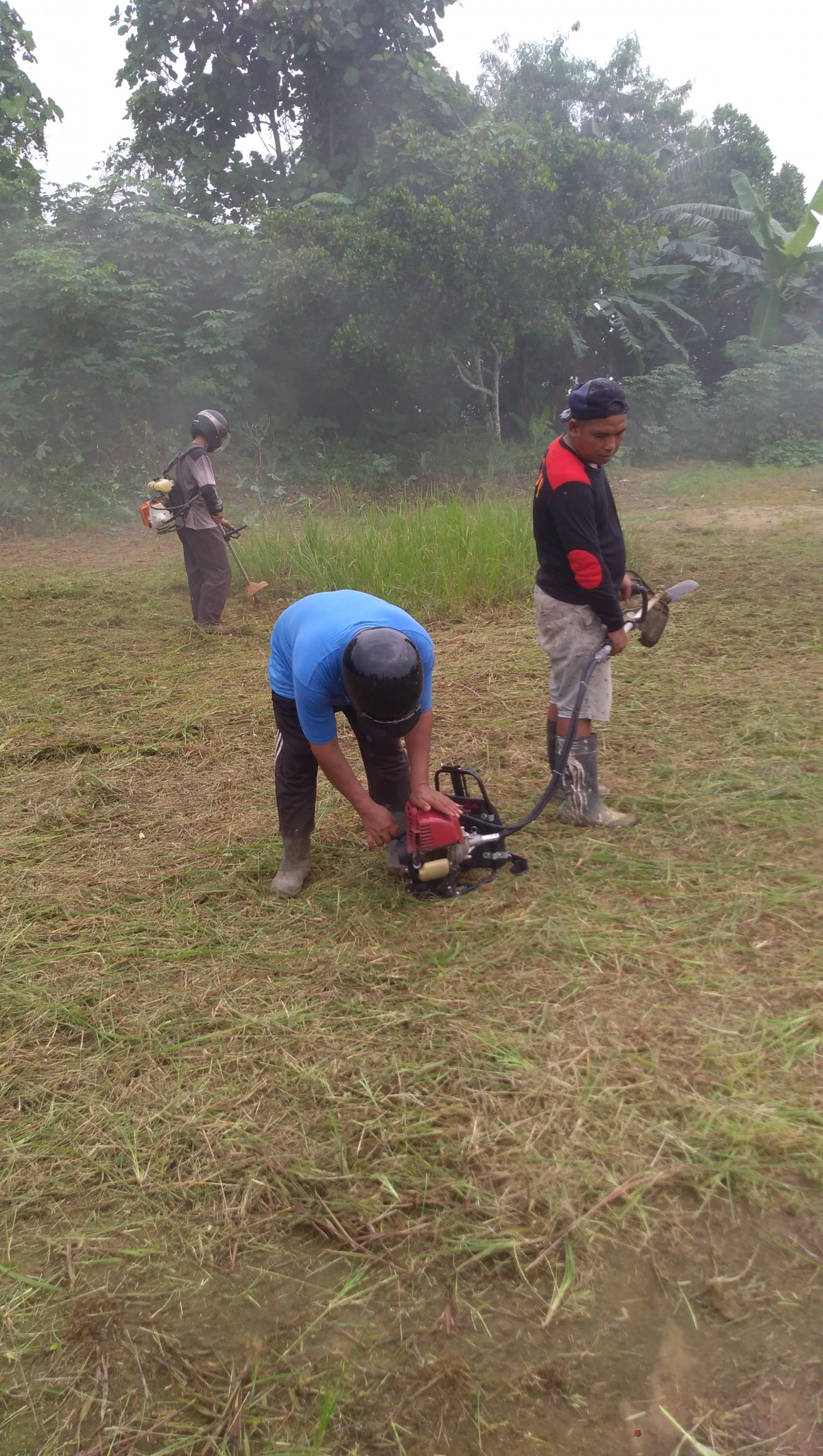 Gotong royong membersihkan lapangan