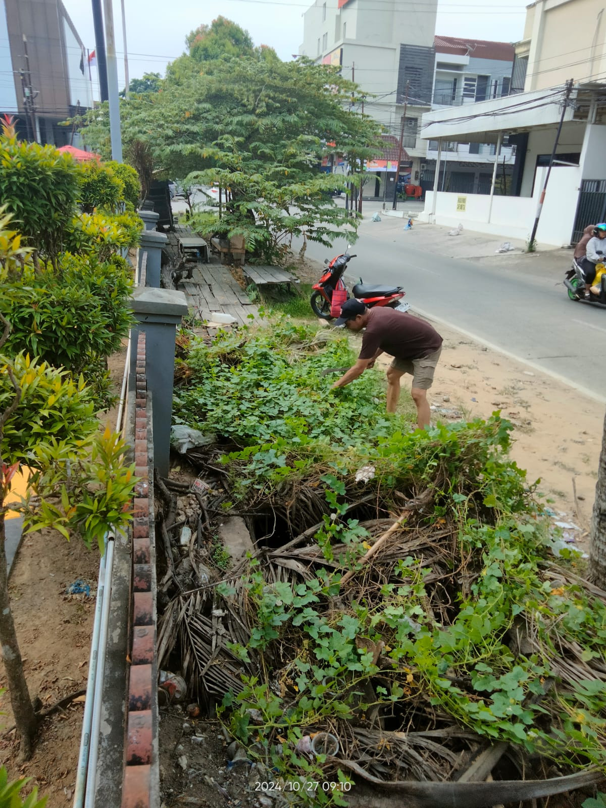 Membersihkan parit dan memotong rumput