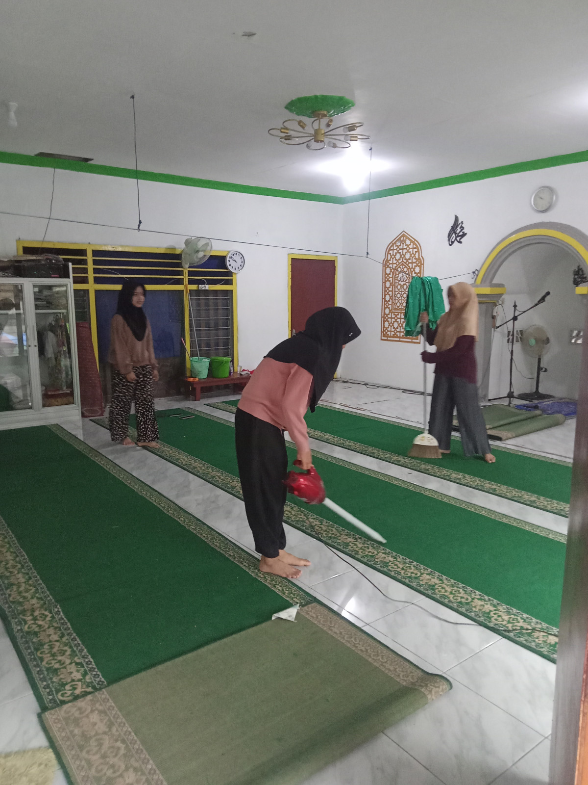 Membersihkan lingkungan musholah AL IKHSAN