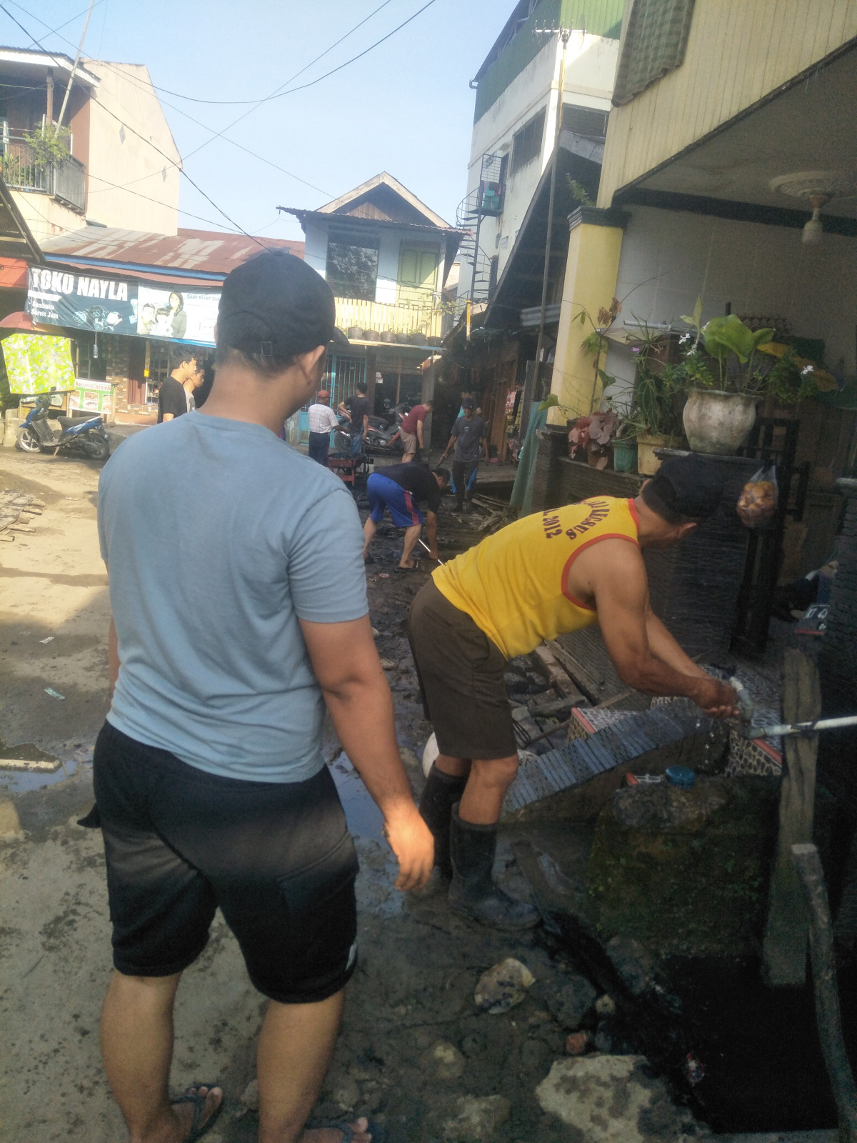 Membersihkan paret di Gang Mandiri.