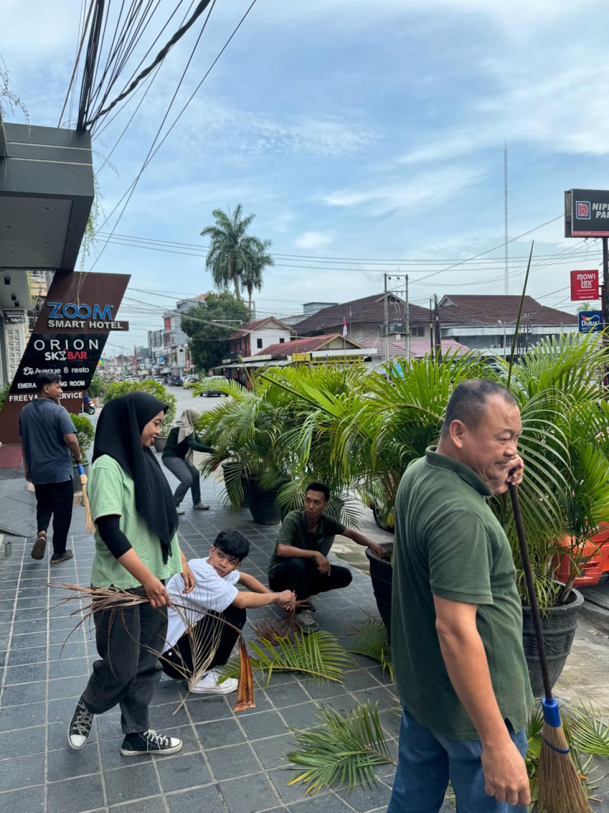 Membersihkan Rumput-Rumput Dihalaman Toko-Toko/Hotel