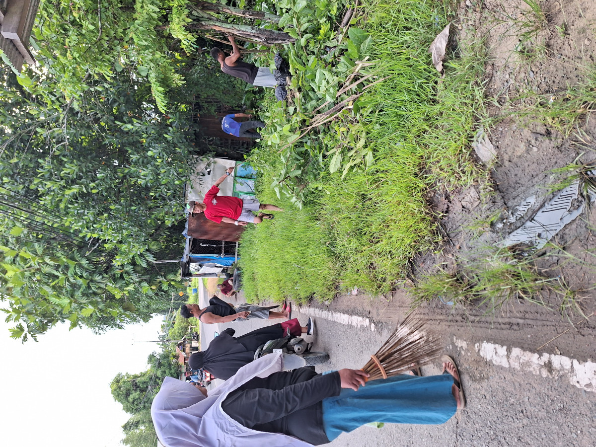 Pemangkasan dahan dan ranting pohon di pinggir jalan rt.02